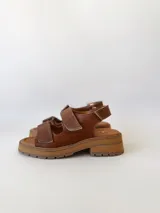 Sandalias de cuero color camel con plataforma y doble tira ancha con hebilla.