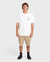 Remera blanca de manga corta con gran estampado en la espalda de diseño tropical, que incluye una palmera, olas y el texto "Billabong Boardshorts Co. Free Since Seventy Three".