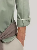 Camisa de hombre color azul, con cuello buttondown, cierre frontal con botones y logo bordado en el pecho. Presenta un acabado vintage logrado mediante el proceso de teñido en prenda.