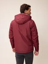 Campera de nylon gris con capucha, cierre frontal completo y bolsillos laterales. Presenta un diseño minimalista con logo bordado en el pecho.