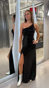 Vestido largo de fiesta negro con lentejuelas, corte ajustado, un solo hombro y abertura en la pierna.
