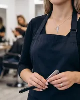 Collar de plata 925 con dije doble que representa un peine y una tijera, ambos decorados con pequeñas circonias.