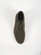 Bota tipo leñadora color verde oliva, con cordones al tono, cuello de pana acanalada y suela de goma dentada en color tostado.