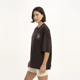Remera marrón de corte holgado con estampado de flores en el pecho.