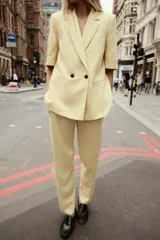 Pantalón de vestir amarillo pálido, de tiro alto, corte recto y largo a la altura del tobillo.