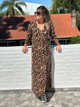 Vestido largo de lanilla color fucsia con estampado animal print negro, de corte recto y mangas largas.