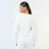Buzo blanco de cuello redondo, con mangas largas abullonadas y diseño holgado.