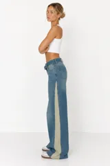 Jeans wide leg de tiro medio, confeccionados en denim azul con franjas laterales en contraste de color beige y diseño de doble cintura.