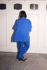 Blazer azul de lino con corte holgado, solapas y cuatro botones fucsia.