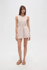 Short de tiro alto con diseño de rayas verticales en tonos beige y blanco. Presenta una cintura elástica con detalle de volado y cordón ajustable para atar al frente. Su corte es holgado y cómodo.