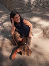 Pantalón a cuadros de corte ligeramente oxford, con cierre y elástico en la cintura, detalle de triángulo de cuero en la pretina y logo bordado en la pierna.