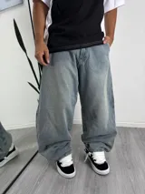 Jean de corte baggy con diseño holgado y tiro medio, confeccionado en denim de lavado claro con efecto desgastado.