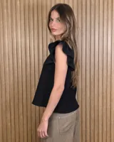 Musculosa de lino color marrón con mangas con volantes y cuello redondo.