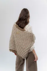 Buzo de punto grueso con diseño bicolor en patrón geométrico, de calce holgado y mangas largas.