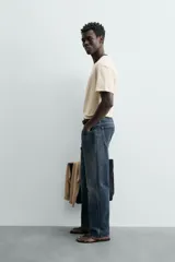 Camiseta de manga corta y cuello redondo, color azul marino, con ribete de contraste en color crema alrededor del cuello.