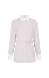 Camisa de algodón con estampado de rayas verticales en tonos rosa y blanco. Presenta cuello clásico, mangas largas con puños anchos en contraste y un detalle de pañuelo integrado en el cuello que simula una corbata. Posee cierre frontal de botones y corte recto.