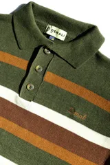 Buzo tejido de punto con diseño de rayas horizontales en tonos verde, marrón y blanco. Presenta cuello tipo polo con cierre de tres botones, mangas largas con puños acanalados y logo de la marca bordado en el pecho. Incluye una etiqueta decorativa en la parte inferior.