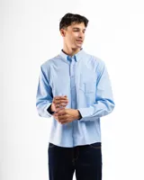 Camisa celeste de corte clásico, con cuello abotonado, manga larga y bolsillo en el pecho.