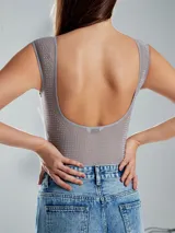 Body gris claro de lycra con cuello redondo y sin mangas, con pequeños apliques brillantes.