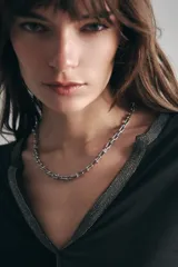 Collar de cadena de metal plateado con eslabones de diseño rectangular y esferas decorativas en las uniones.