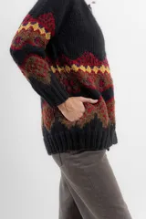 Saco de lana y poliamida negro con diseño geométrico en amarillo, rojo y marrón. Tiene silueta recta, largo debajo de la cola, bolsillos en los costados, escote polo y cierre frontal con botones.