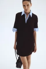 Vestido corto negro de manga corta y corte recto, con escote en V pronunciado en la parte delantera.