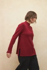 Polera negra de jacquard con cuello alto y aberturas en los laterales y en las mangas.