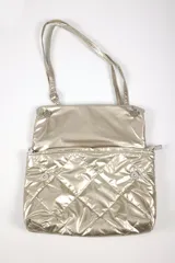 Cartera acolchada color dorado, con solapa frontal, asa de cadena y correa ajustable para el hombro.