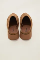 Zueco tipo mule de gamuza color camel, con plataforma de goma al tono y costura central decorativa.