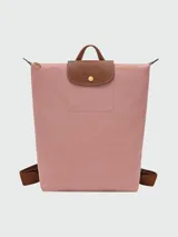 Mochila Longchamp modelo Le Pliage Original en tamaño M, color rosado con solapa y detalles en cuero marrón. Cuenta con correas ajustables de tela y cierre superior con solapa de botón a presión.