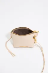 Monedero mini de piel vacuna con estructura blanda, cierre de cremallera superior, asa extraíble y logo metálico frontal de la marca.