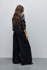 Jean wide leg negro de tiro alto, con calce amplio y pierna extra ancha, de líneas limpias.