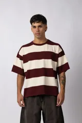 Remera de tejido de punto con diseño de rayas horizontales anchas en color bordó y crema, de corte oversize y cuello redondo.