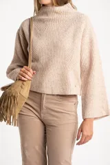 Sweater de punto acanalado color marrón, con cuello alto tipo polera y mangas largas de corte ancho. Posee un diseño oversize confeccionado en mezcla de lana.