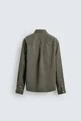 Camisa de corte relajado confeccionada en una mezcla de lyocell y algodón con efecto lavado. Presenta cuello solapa, manga larga con puños abotonados, bolsillo de plastrón en el pecho y cierre frontal con botones.