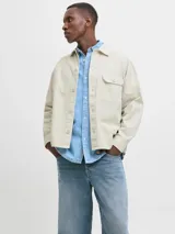 Sobrecamisa de manga larga confeccionada en sarga de algodón, con cuello camisero, cierre frontal de botones y un bolsillo en el pecho. Presenta un corte amplio y estructura versátil ideal para usar como capa ligera.