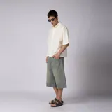 Camisa de manga corta color marfil, confeccionada en 100% algodón con calce boxy, cuello camisero, cierre frontal de botones y diseño con bordado sutil en la parte inferior.