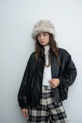 Chaqueta de cuero sintético color negro, de corte oversize, con cierre frontal, cuello camisero y puños elásticos.