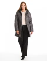 Campera matelassé color verde militar, con diseño de pespuntes en forma de ondas. Presenta cierre frontal completo, cuello alto, capucha fija acolchada y bolsillos laterales invisibles. Su corte es holgado y llega por debajo de la cadera.