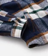 Campera de franela a cuadros con forro interno de sherpa, cuello tipo polo, cierre frontal con botones y bolsillos frontales con solapa.