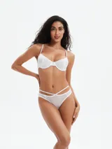 Conjunto de bikini negro, con corpiño tipo push-up con tirantes finos y bombacha de corte bajo con tiras cruzadas en la cintura.