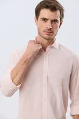 Camisa de lino a rayas finas en tonos beige y blanco, de manga larga con puños vueltos, cuello camisero y cierre frontal de botones. Cuenta con un pequeño logo bordado en el pecho.