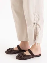 Pantalon de tiro medio color beige, confeccionado en twill, con fit relajado, pierna ancha estilo babucha, bolsillos laterales y traseros tipo ojal, y presillas en la cintura.