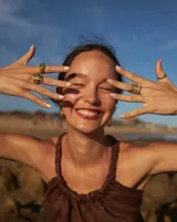 Anillo abierto de diseño orgánico con textura irregular y acabado brillante, realizado artesanalmente en metal.