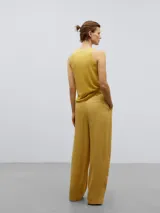 Pantalón recto amarillo con pinzas frontales, bolsillos inclinados y cintura sastre con goma interior.