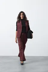 Pantalón de corte recto y tiro medio, color bordó, con pespuntes blancos a contratono y recortes delanteros que le otorgan un estilo utilitario.