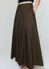 Falda larga color marrón oscuro, con diseño evasé, tiro medio y detalle cruzado tipo pañuelo con cierre de nudo en la cintura.