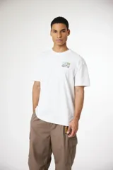 Remera blanca de manga corta con cuello redondo y un pequeño estampado gráfico en el pecho que incluye las letras 'XXX', 'Japan Journal' y texto en japonés.