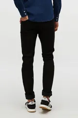 Jean skinny negro de tiro medio, con cierre de botón y cremallera, y bolsillos delanteros y traseros.