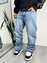 Pantalón jean de corte holgado y estilo flared, con lavado claro y diseño en el dobladillo.
